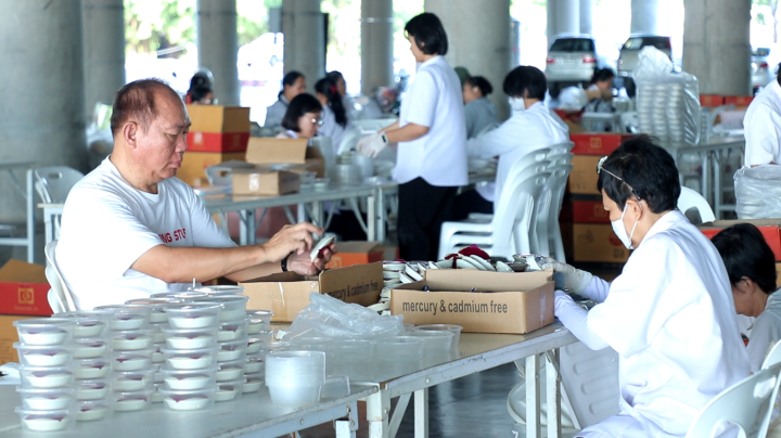 เจ้าหน้าที่วัดพระธรรมกาย และสาธุชน ร่วมกันใส่ถ่าน LED  เพื่อใช้จุดประทีปวันธรรมชัย