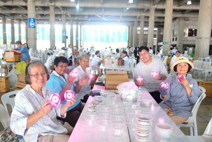 เจ้าหน้าที่วัดพระธรรมกาย และสาธุชน ร่วมกันใส่ถ่านประทีป LED เพื่อใช้จุดประทีปวันวิสาขบูชา