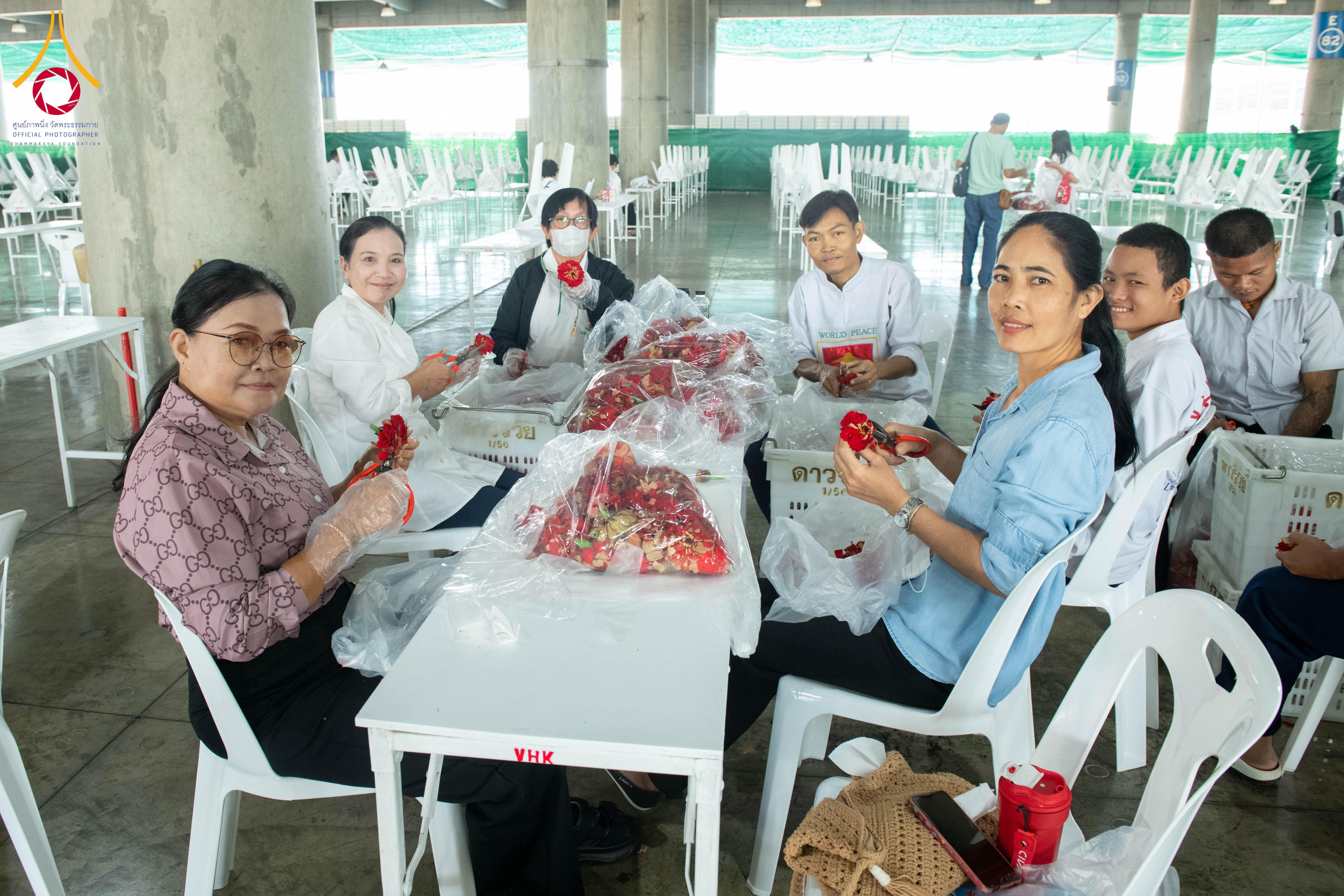 เจ้าหน้าที่วัดพระธรรมกาย และสาธุชน รับบุญปลิดกลีบดอกเบญจทรัพย์ และทรัพย์บานชื่น