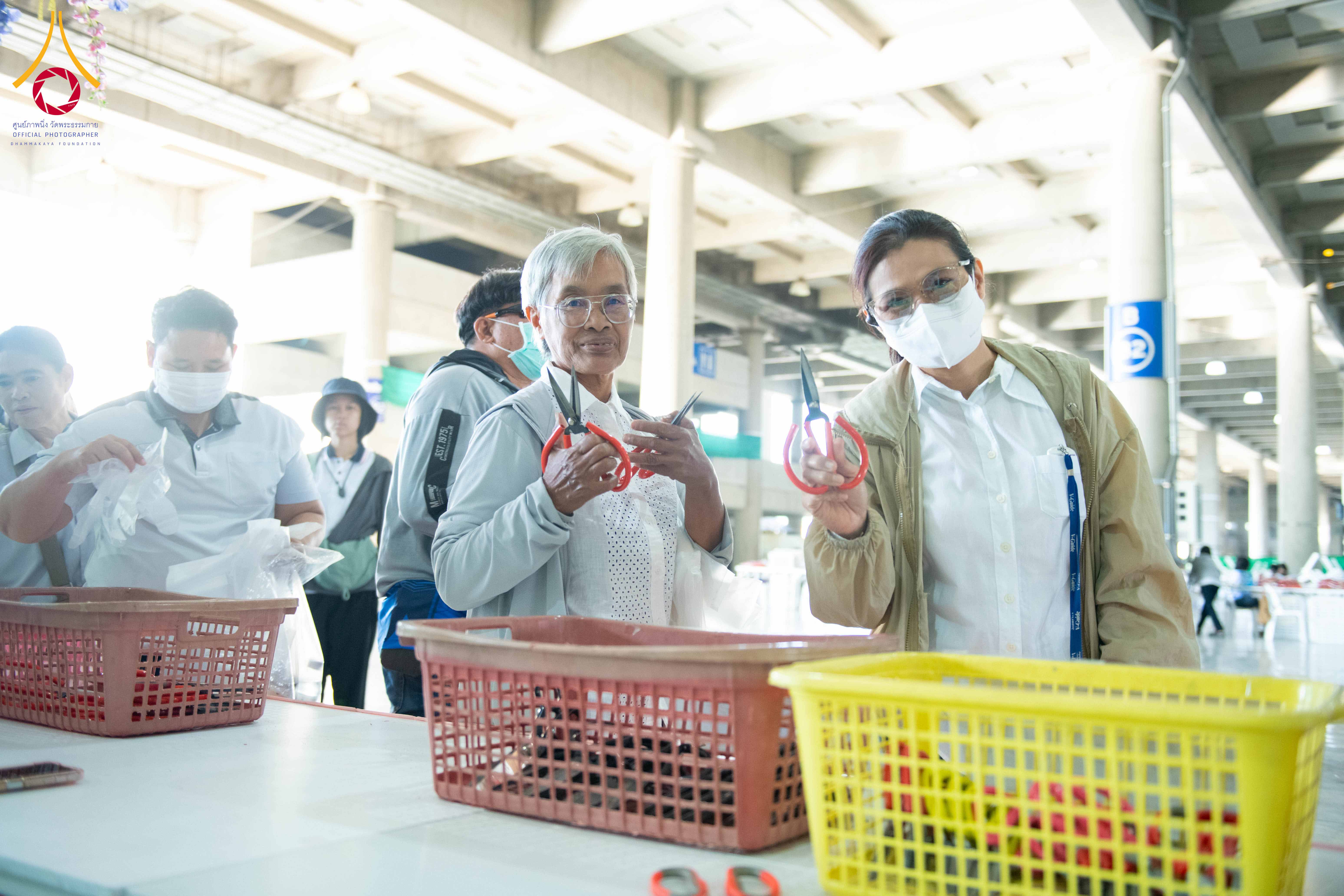 เจ้าหน้าที่วัดพระธรรมกาย และสาธุชน รับบุญปลิดกลีบดอกเบญจทรัพย์ และทรัพย์บานชื่น