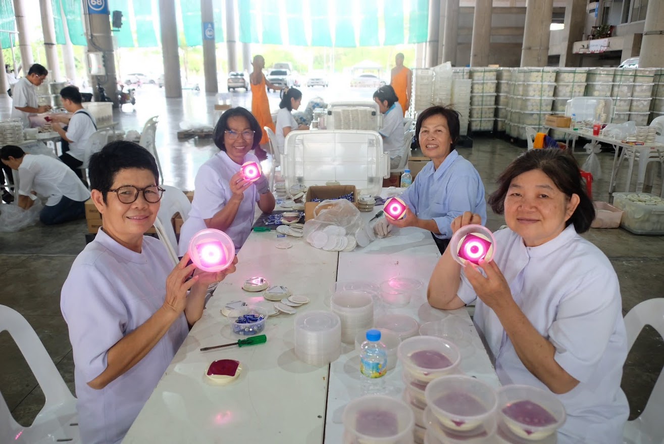 เจ้าหน้าที่วัดพระธรรมกาย และสาธุชน ร่วมกันใส่ถ่านประทีป LED เพื่อใช้จุดประทีปวันวิสาขบูชา
