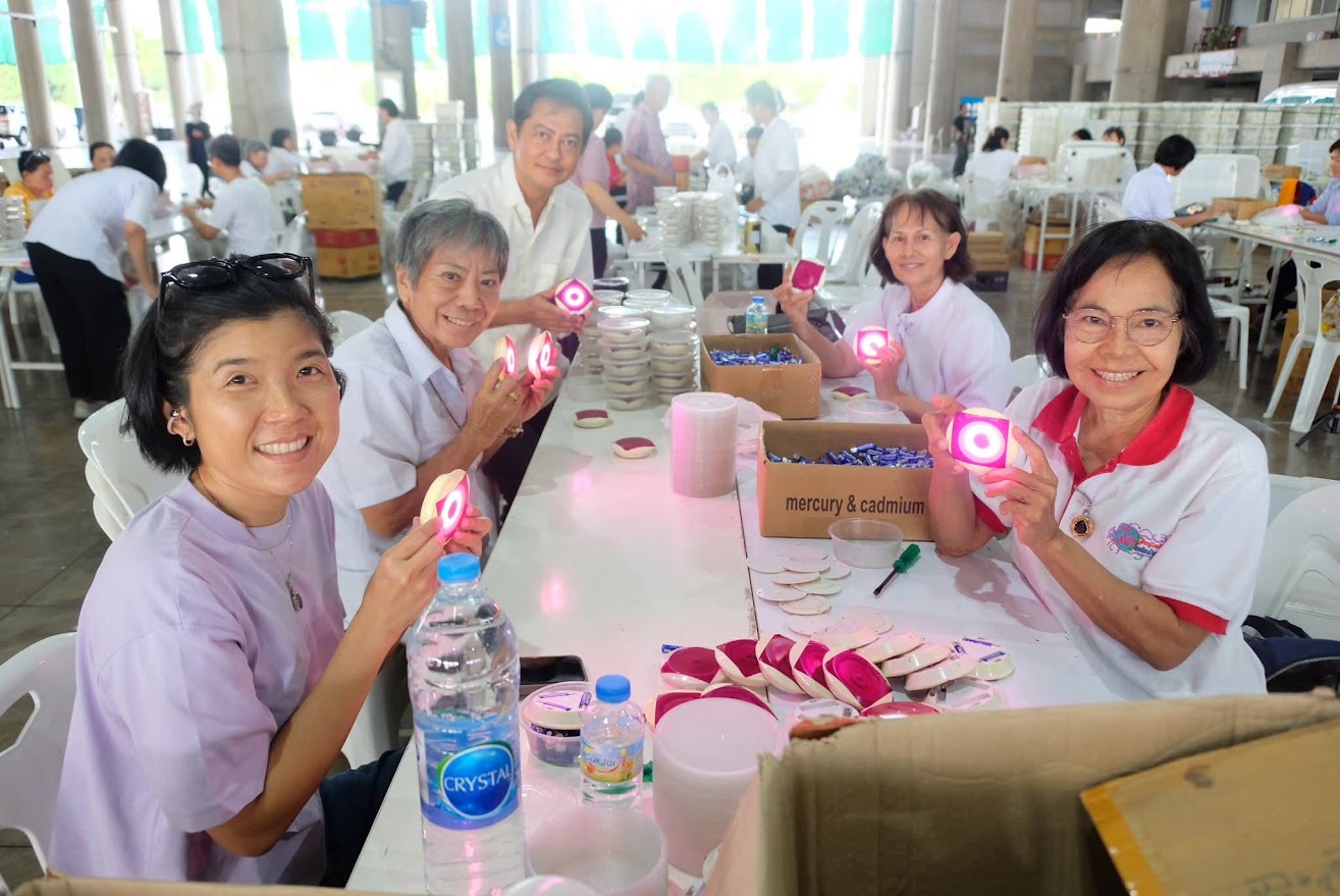 เจ้าหน้าที่วัดพระธรรมกาย และสาธุชน ร่วมกันใส่ถ่านประทีป LED เพื่อใช้จุดประทีปวันวิสาขบูชา
