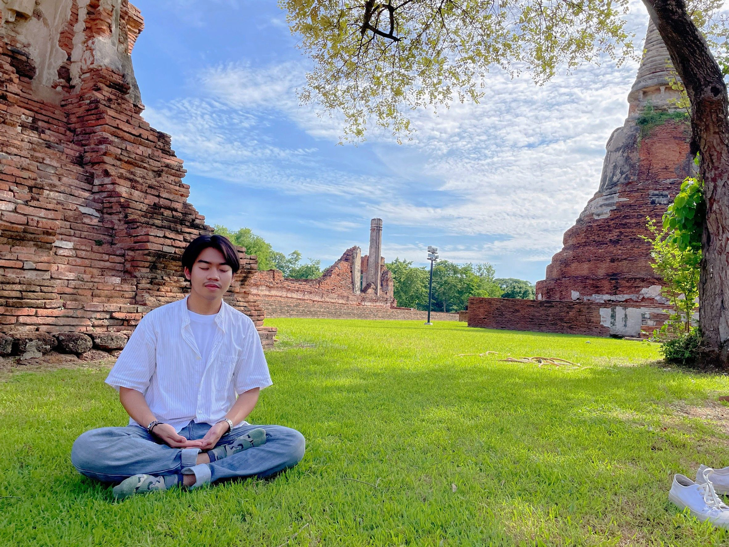 ชายหนุ่มนั่งสมาธิที่โบราณสถาน